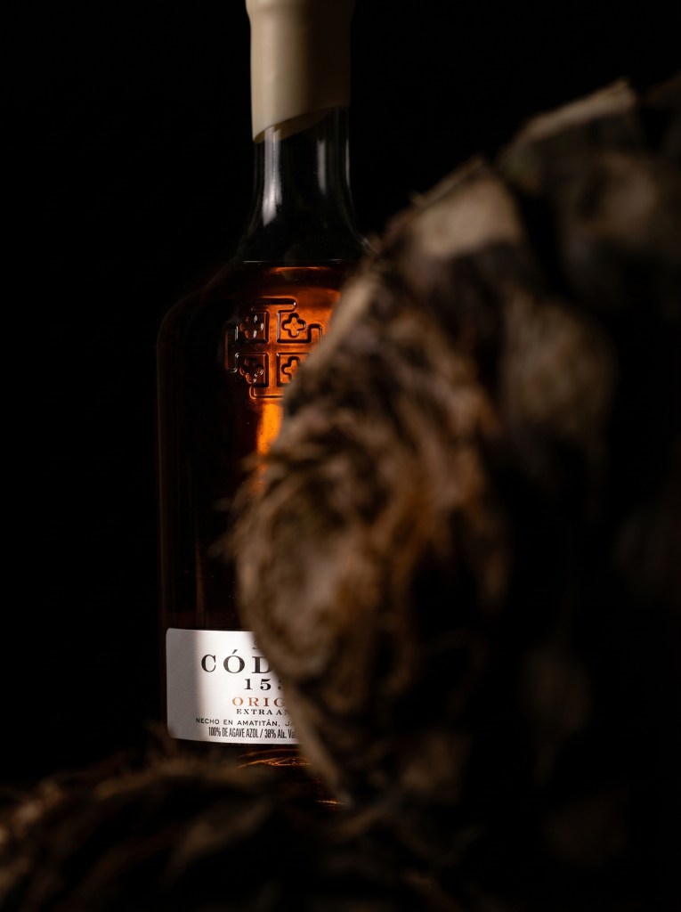 Código 1530 tequila bottle against amber stone backdrop